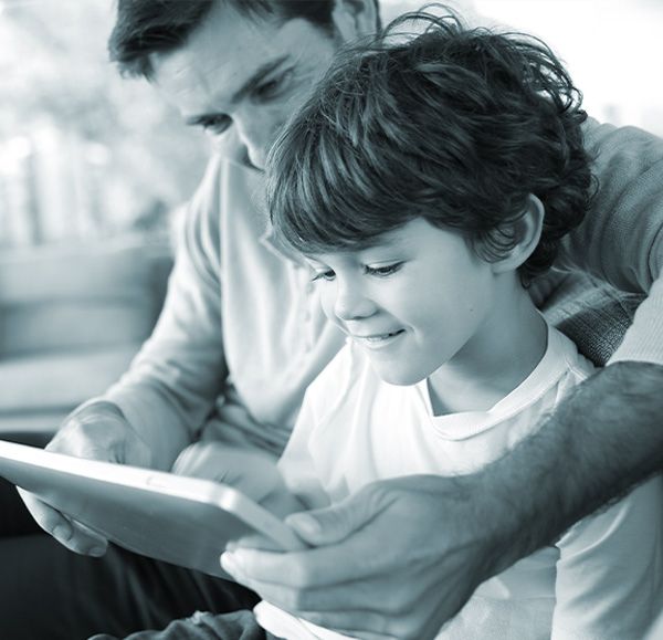 A man with a child looking at a tablet